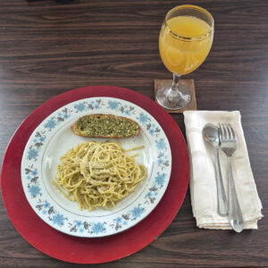 Plate of Spicy Pasta, Fork and Knife and glass of juice